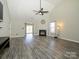 Spacious living room with vaulted ceilings, modern fan, fireplace and gray wood floors, creating a cozy atmosphere at 7220 Hidden Creek Dr, Charlotte, NC 28214