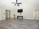 Open living space featuring vaulted ceilings, wood floors, and a modern entertainment area with large-screen tv at 7220 Hidden Creek Dr, Charlotte, NC 28214