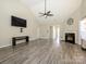 Spacious living room with vaulted ceilings, modern fan, fireplace and gray wood floors, creating a cozy atmosphere at 7220 Hidden Creek Dr, Charlotte, NC 28214