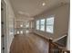 An open-concept living room with hardwood floors, large windows, and iron railing, complete with modern finishes at 7441 Fighting Creek Rd # 30, Sherrills Ford, NC 28673