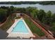 High angle view of a triangular community pool with a nearby lake, surrounded by lush greenery and walking paths at 7441 Fighting Creek Rd # 30, Sherrills Ford, NC 28673