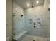 A luxurious shower features a glass enclosure, marble tile, and bronze fixtures at 7441 Fighting Creek Rd # 30, Sherrills Ford, NC 28673