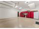 Spacious garage featuring epoxy flooring, red storage cabinets, a workbench, and a white refrigerator at 7461 Barrington Ridge Dr # 33, Indian Land, SC 29707