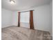 Bright bedroom features neutral carpet, white walls, and a window dressed with drapes at 801 Long Shoals Rd, Lincolnton, NC 28092