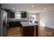 Open kitchen with dark wood cabinetry, stainless steel appliances, island, and dining area at 801 Long Shoals Rd, Lincolnton, NC 28092