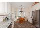 Bright dining area with white cabinets, granite counters, stainless steel fridge, and adjacent table at 9130 Twilight Hill Ct, Charlotte, NC 28277