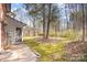 View of a lush green backyard with mature trees, screen porch, and a concrete patio, perfect for outdoor enjoyment at 1035 Nw Wexford Pl # D3, Concord, NC 28027