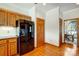 Kitchen with hardwood floors, wood cabinets, and black refrigerator at 11 Courageous St, Lake Wylie, SC 29710