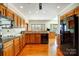 Kitchen features hardwood floors, wood cabinets, black appliances, and view to the deck at 11 Courageous St, Lake Wylie, SC 29710