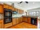 Kitchen with hardwood floors, wood cabinets, and black appliances at 11 Courageous St, Lake Wylie, SC 29710