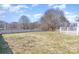 Large backyard offering ample space with a deck, wooden fence, and mature trees at 110 Weeping Willow Way, Gastonia, NC 28052