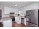 Well-lit kitchen featuring white cabinetry, stainless steel appliances, and dark hardwood flooring at 110 Weeping Willow Way, Gastonia, NC 28052