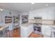Modern kitchen featuring white cabinets, stainless steel appliances, hardwood floors, and an adjacent breakfast nook at 110 Weeping Willow Way, Gastonia, NC 28052