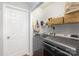 Organized laundry room with modern washer and dryer, storage shelves, and a white door at 110 Weeping Willow Way, Gastonia, NC 28052