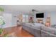 Cozy living room with a brick fireplace, large windows, hardwood floors, and a comfortable gray sofa at 110 Weeping Willow Way, Gastonia, NC 28052