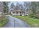 A home with a long driveway and a cozy front porch surrounded by lush greenery at 121 Wonderwood Dr, Charlotte, NC 28211