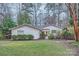 Well-manicured exterior of the house surrounded by lush greenery and mature trees at 121 Wonderwood Dr, Charlotte, NC 28211