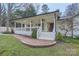 Inviting covered front porch with ceiling fans and a brick walkway leading to the entrance at 121 Wonderwood Dr, Charlotte, NC 28211
