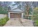 Detached garage with a large wooden door and concrete driveway, surrounded by a black metal fence at 121 Wonderwood Dr, Charlotte, NC 28211
