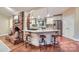 Open kitchen design featuring a brick fireplace and a granite island with barstool seating at 121 Wonderwood Dr, Charlotte, NC 28211