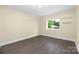 Bright bedroom featuring wood-look flooring, neutral paint, and a window with backyard views at 1323 Queens Rd # 218, Charlotte, NC 28207