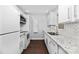 Efficient kitchen featuring white cabinets, granite countertops, and stainless steel appliances at 1323 Queens Rd # 218, Charlotte, NC 28207