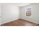 Sunlit bedroom with sleek hardwood floors and a large window overlooking the backyard at 1428 Nature Pl, Charlotte, NC 28214