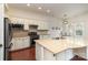 Kitchen featuring a granite island, white cabinets, stainless steel appliances, and hardwood floors at 15727 Kiser Corner Ln, Davidson, NC 28036