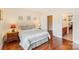 Bedroom with a queen sized bed, hardwood flooring, and adjoining bathroom at 16506 Doves Canyon Ln, Charlotte, NC 28278