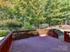 A wooden deck overlooks a landscaped backyard with mature trees and shrubs at 16506 Doves Canyon Ln, Charlotte, NC 28278