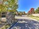 Gated entrance to a community with lush landscaping and a stone guardhouse at 16506 Doves Canyon Ln, Charlotte, NC 28278