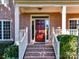 Covered entry to the home with brick steps and wood front door at 16506 Doves Canyon Ln, Charlotte, NC 28278