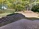 Brick patio area features a retaining wall with lush landscaping at 16506 Doves Canyon Ln, Charlotte, NC 28278
