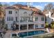 Expansive backyard featuring a pool, patio seating, and a spiral staircase to the upper deck at 18302 Town Harbour Rd, Cornelius, NC 28031