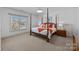 Well-lit bedroom with a four poster bed, neutral carpet, and lake view at 18302 Town Harbour Rd, Cornelius, NC 28031