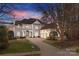 Elegant two-story home with a brick driveway, manicured lawn, and a three-car garage at 18302 Town Harbour Rd, Cornelius, NC 28031