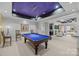 Entertaining game room featuring a pool table and seamless flow into a cozy sitting area with fireplace at 18302 Town Harbour Rd, Cornelius, NC 28031