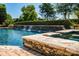 Gorgeous pool area with a waterfall feature and lush greenery at 18302 Town Harbour Rd, Cornelius, NC 28031