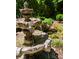 Close up of a tiered water fountain with intricate carvings amidst lush greenery at 18302 Town Harbour Rd, Cornelius, NC 28031