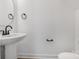 A minimalist powder room with a pedestal sink and modern black fixtures against white walls at 207 E Rice St, Landis, NC 28088