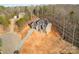 Aerial view of a gray brick home featuring a paved driveway, many windows, and an unfinished yard at 240 Mark Ryan Ln, Dallas, NC 28034