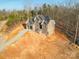 Aerial view of a gray brick home featuring a paved driveway, well-placed windows, and an unfinished yard at 240 Mark Ryan Ln, Dallas, NC 28034