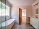 Modern bathroom featuring a freestanding tub, tile floors, and a vanity with sink and open doorway at 240 Mark Ryan Ln, Dallas, NC 28034