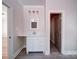 Bathroom with a white vanity, modern fixtures, mirror, gray tile floor, and an open doorway at 240 Mark Ryan Ln, Dallas, NC 28034