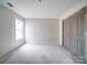Bright bedroom with a double door closet features a window with natural light, and unfinished floors at 240 Mark Ryan Ln, Dallas, NC 28034
