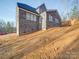 Side view of a gray brick home featuring a well-lit exterior and an unfinished lawn at 240 Mark Ryan Ln, Dallas, NC 28034