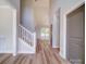 Bright hallway featuring a staircase, modern chandelier, hardwood floors, and decorative wall molding at 240 Mark Ryan Ln, Dallas, NC 28034