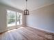 Bright living room featuring a modern chandelier, hardwood floors, and a view of the backyard at 240 Mark Ryan Ln, Dallas, NC 28034