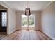 Bright living room featuring a modern chandelier, hardwood floors, and a view of the front yard at 240 Mark Ryan Ln, Dallas, NC 28034