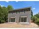 Back exterior of a grey duplex featuring large sliding glass doors that lead to concrete patios at 3627 Rogers St, Charlotte, NC 28208